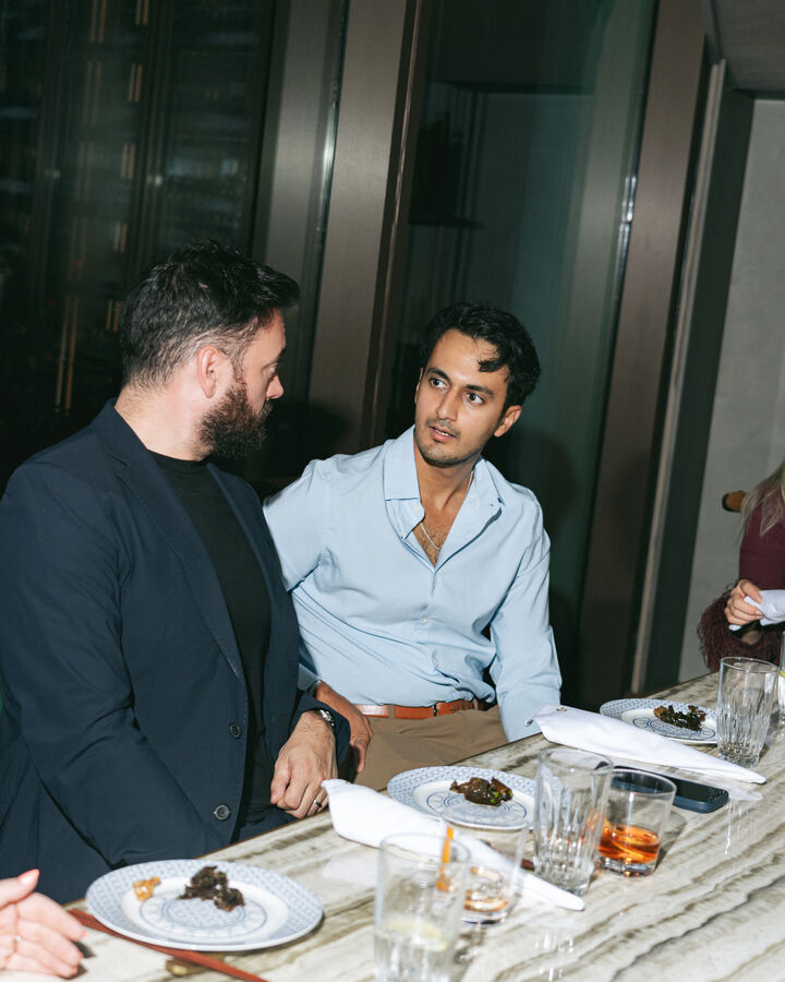 Two people in conversation at a table.